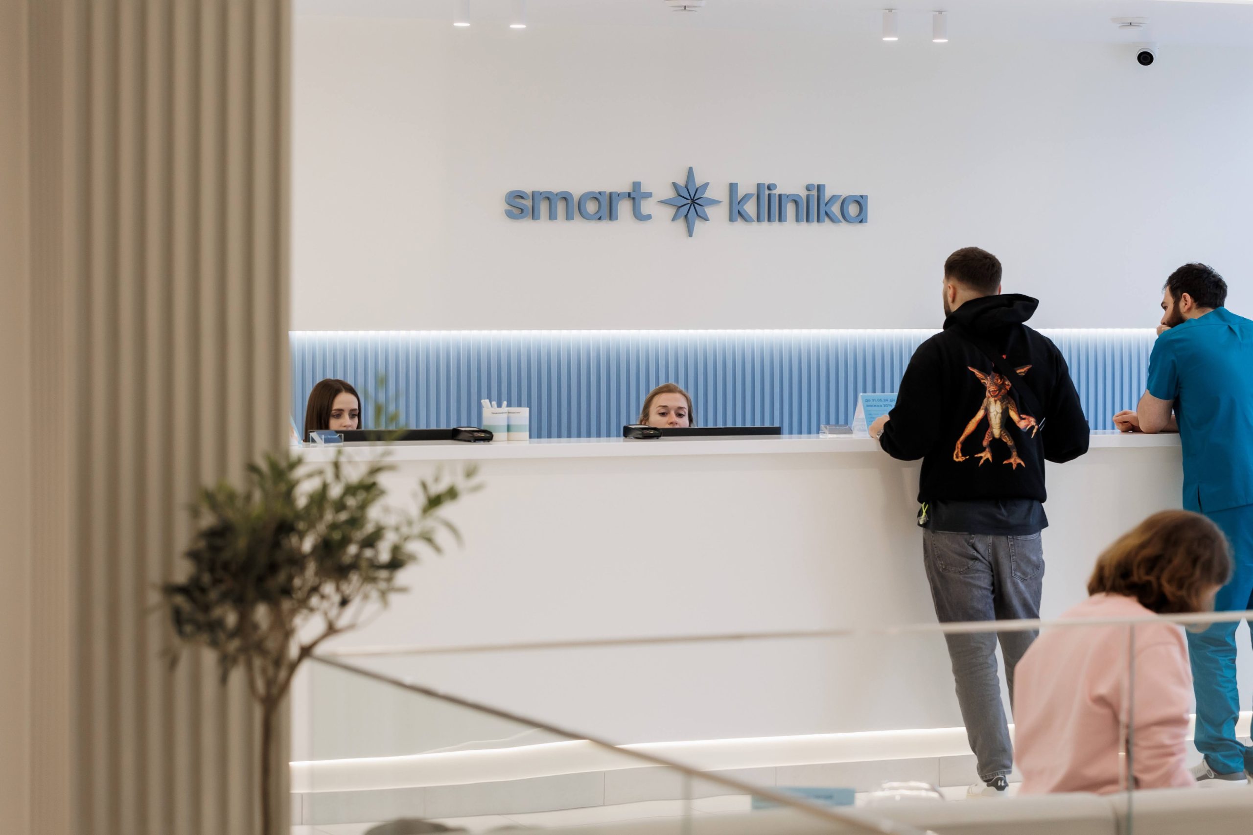 Пацієнт та лікар біля рецепції клініки