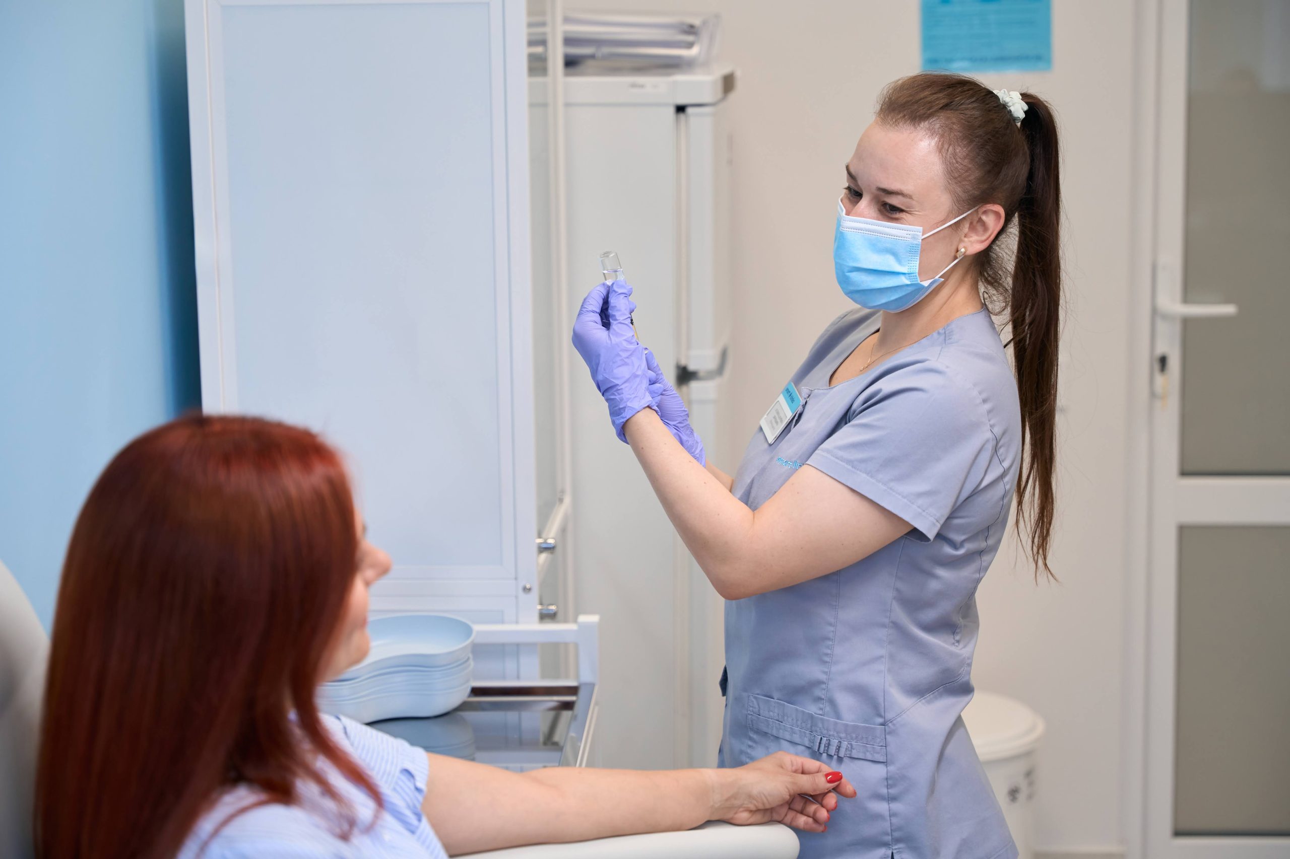 Медична сестра набирає в шприц вакцину