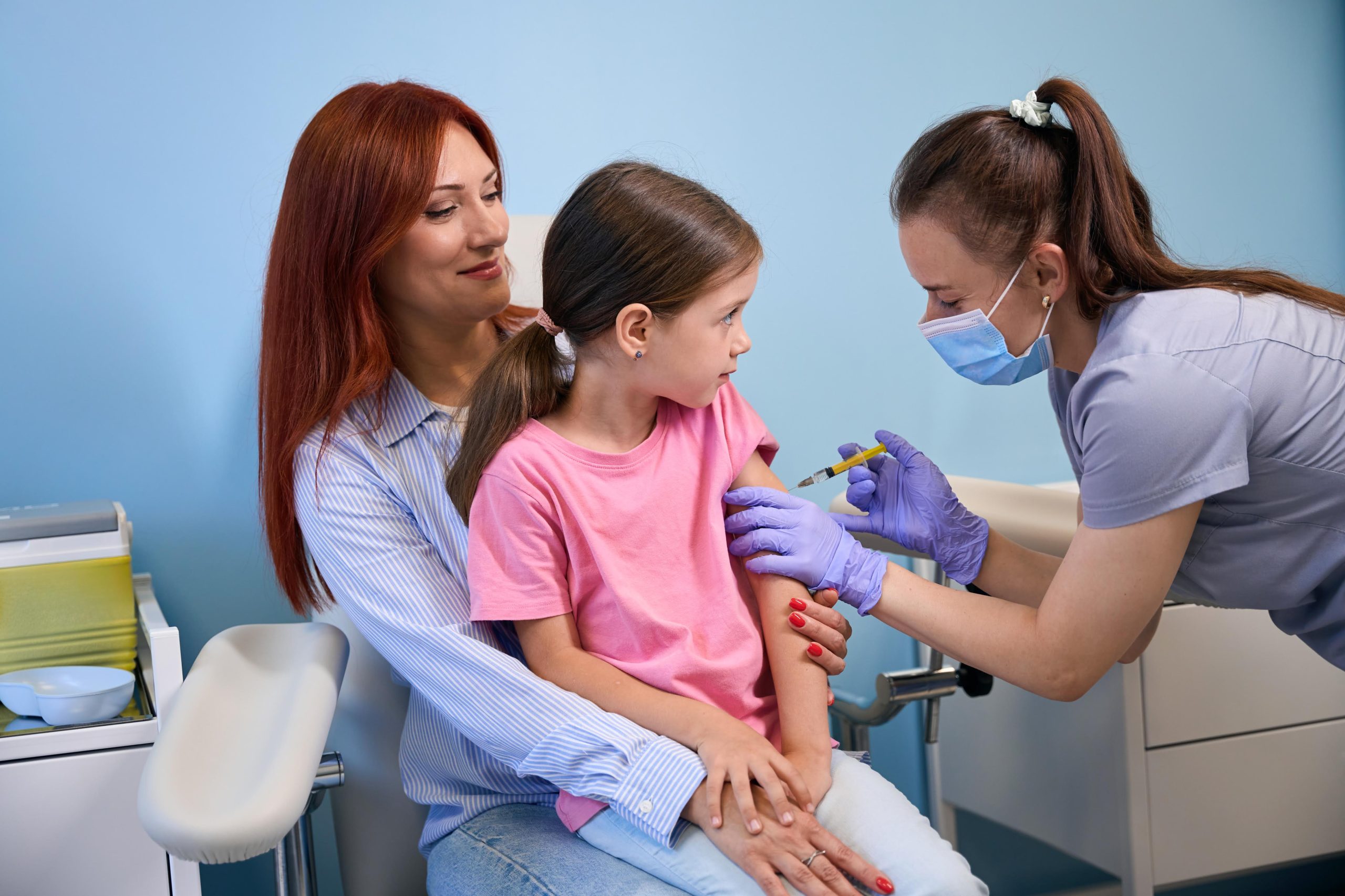 Медична сестра проводить дитині щеплення в маніпуляційній