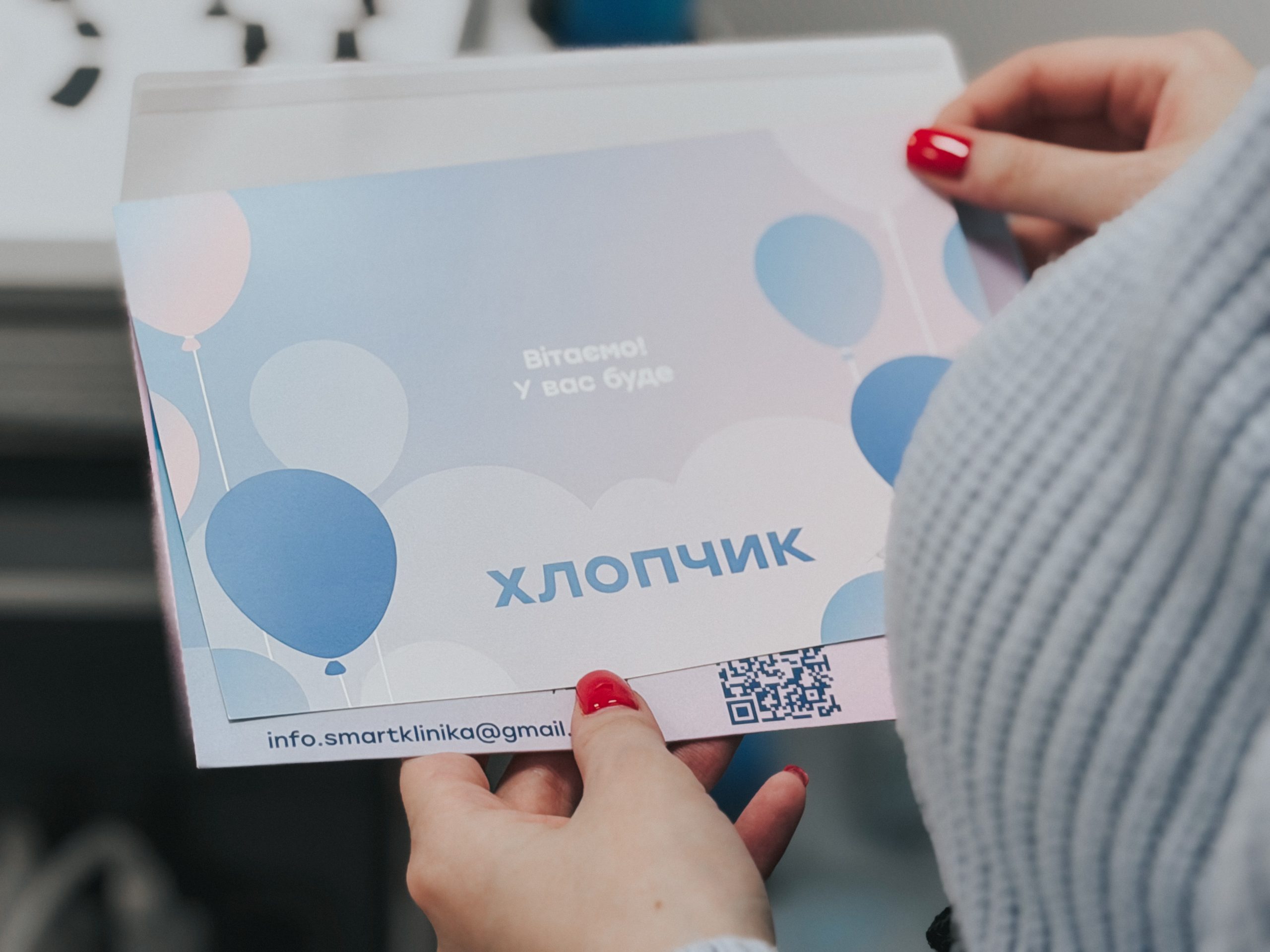 Пацієнтка тримає в руках конверт зі статтю дитини